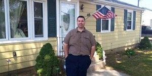 Weatherization client poses outside his home.